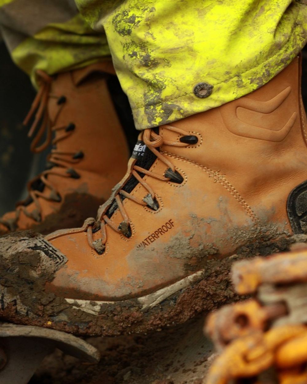 Honey coloured Amblers Safety Mens FS998 Waterproof S3 SRC Safety Boots on muddy background 