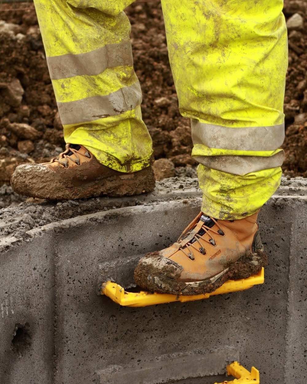 Honey coloured Amblers Safety Mens FS998 Waterproof S3 SRC Safety Boots on muddy background 