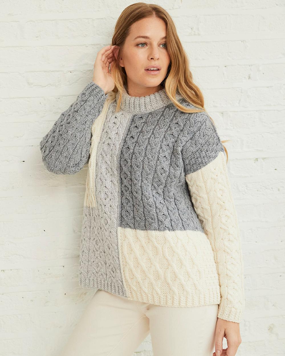 Dawn Coloured Aran Cobh Sweater on grey wall background 