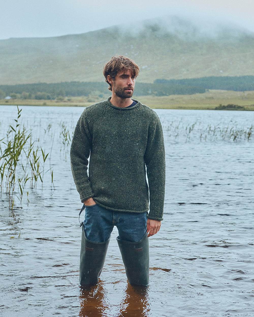 Green Coloured Aran Donegal Wool Crew Neck Sweater on lake background 