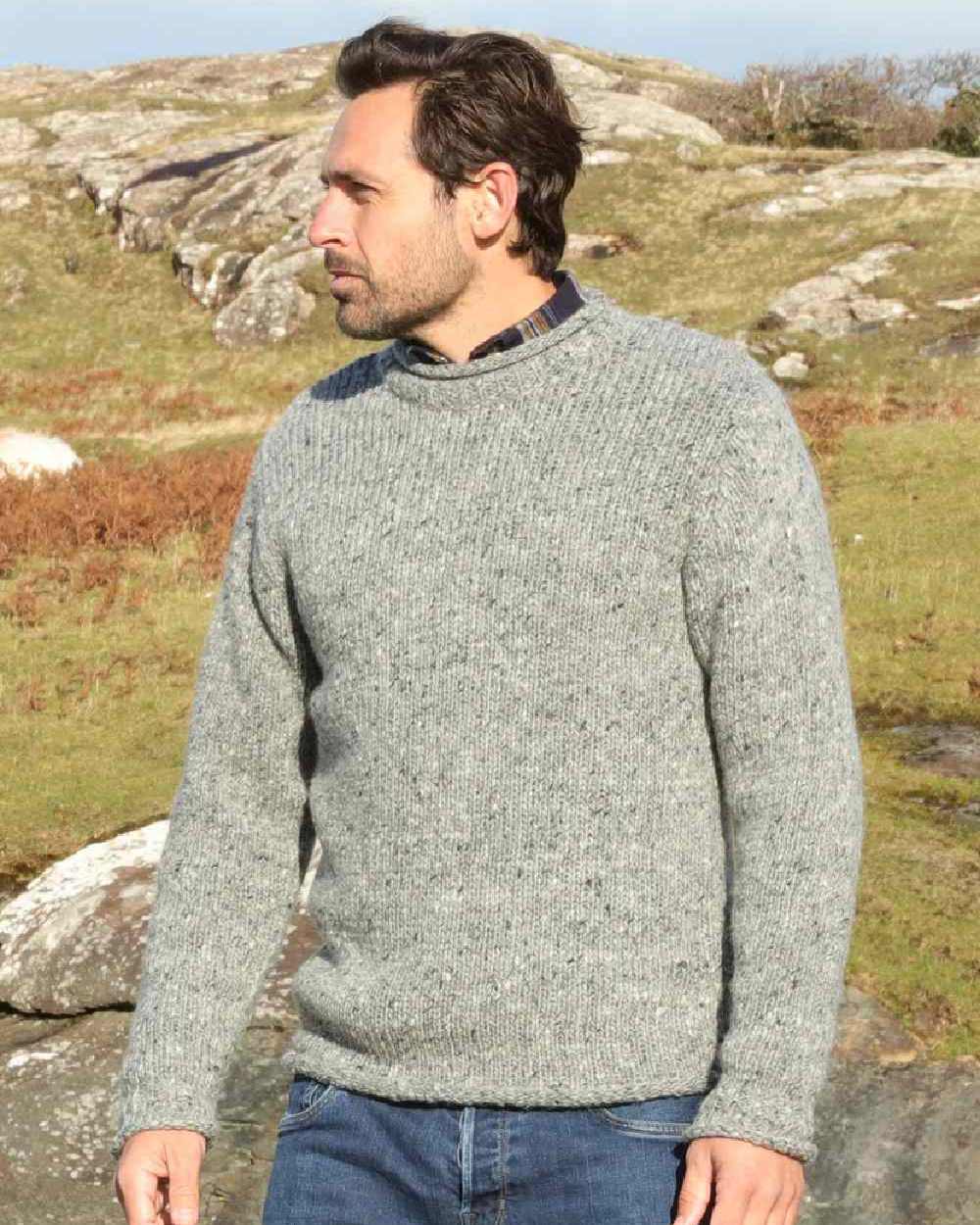 Silver Coloured Aran Donegal Wool Crew Neck Sweater on mountain background 