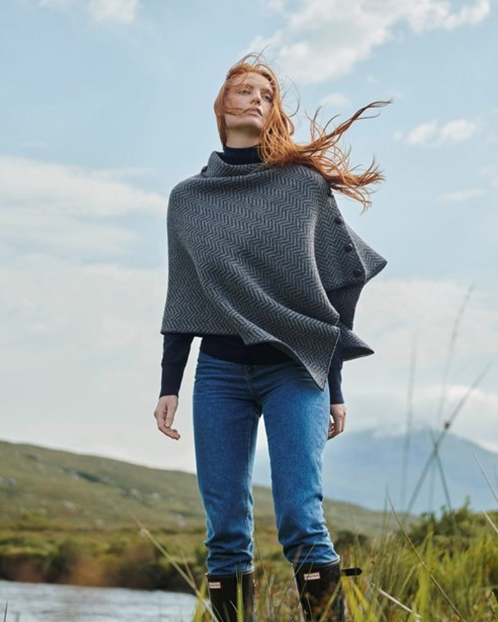 Charcoal Coloured Aran Herringbone Poncho with Buttons on mountain background 