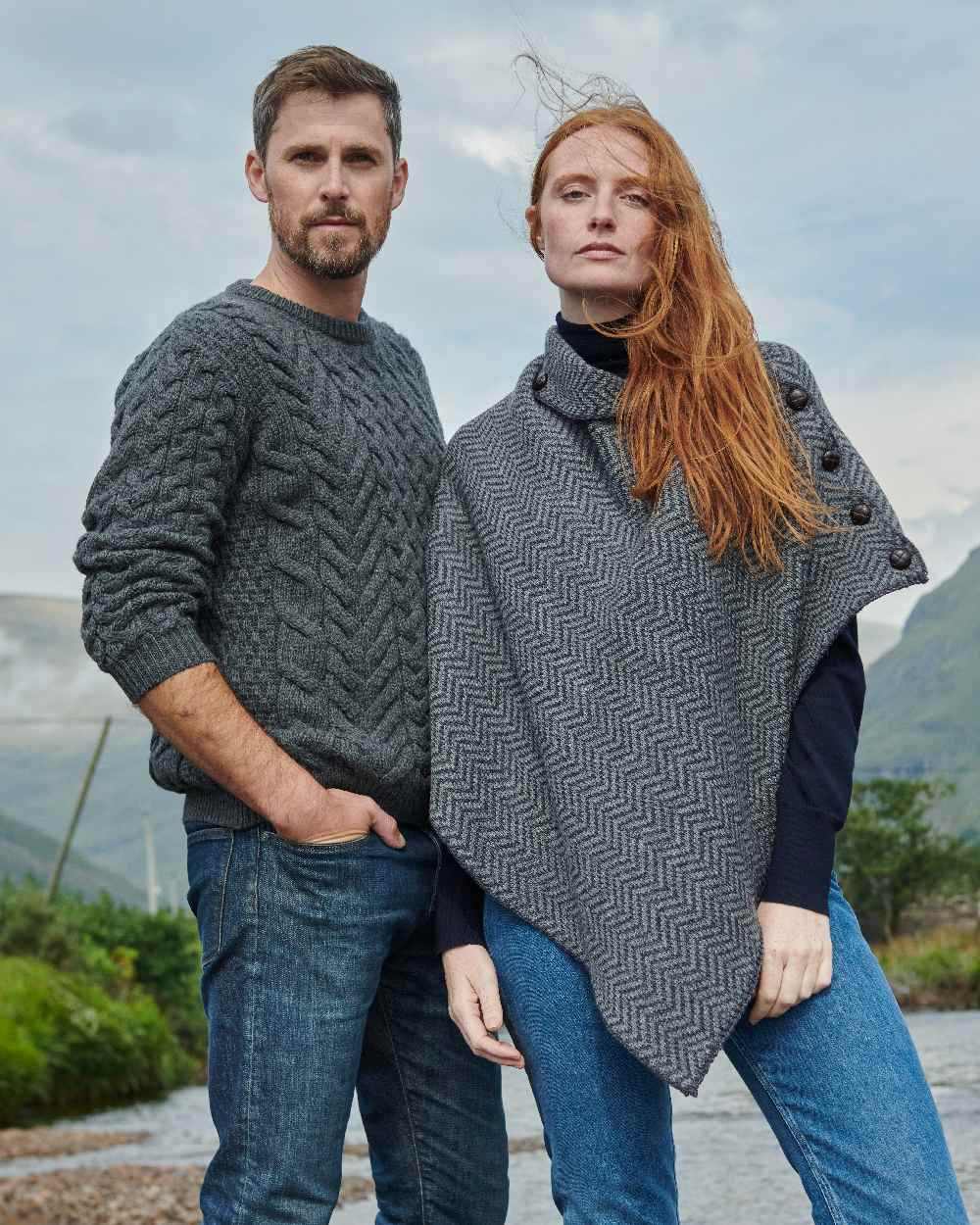 Charcoal Coloured Aran Herringbone Poncho with Buttons on mountain background 