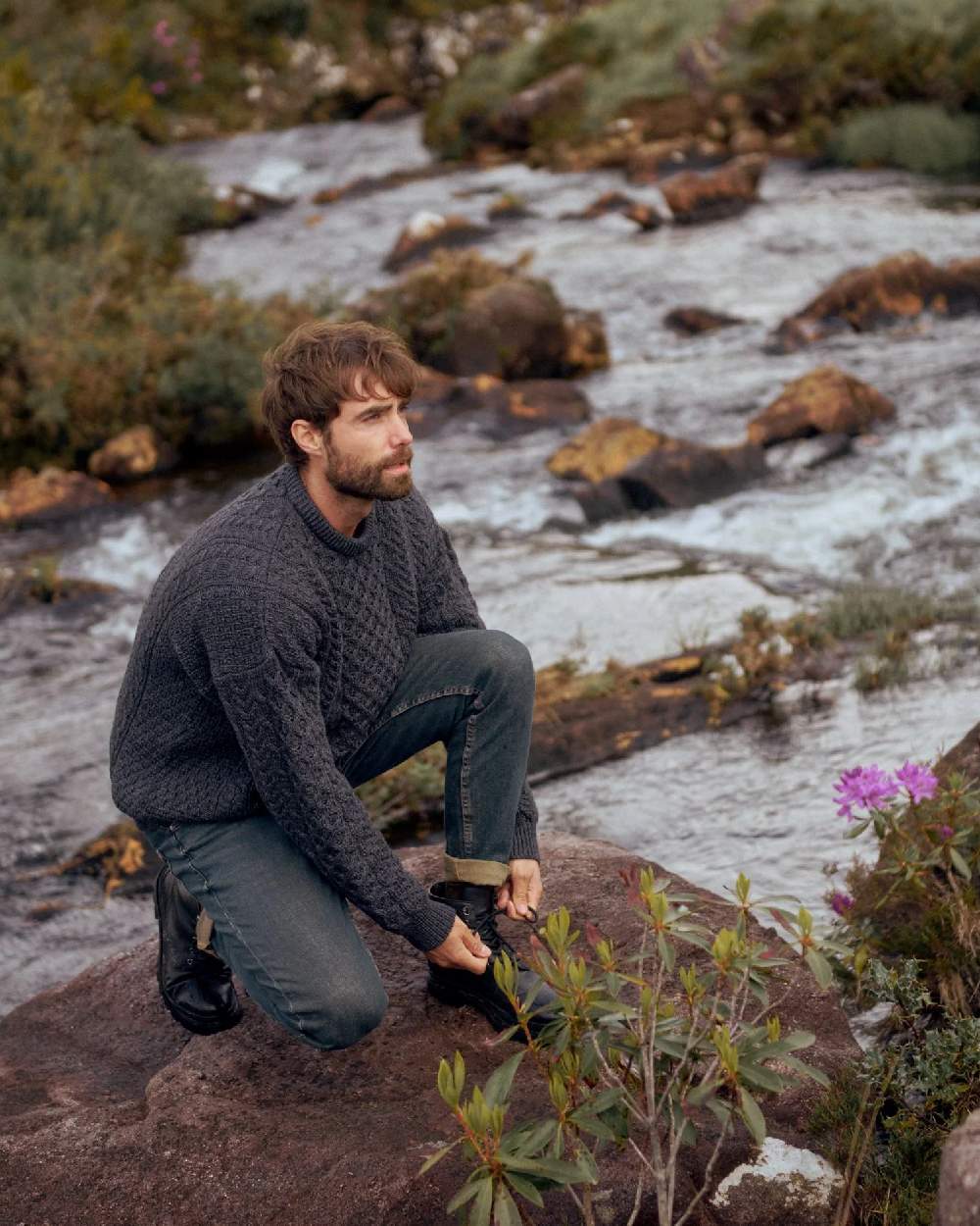 Charcoal Coloured Aran Inisheer Traditional Sweater on river background 