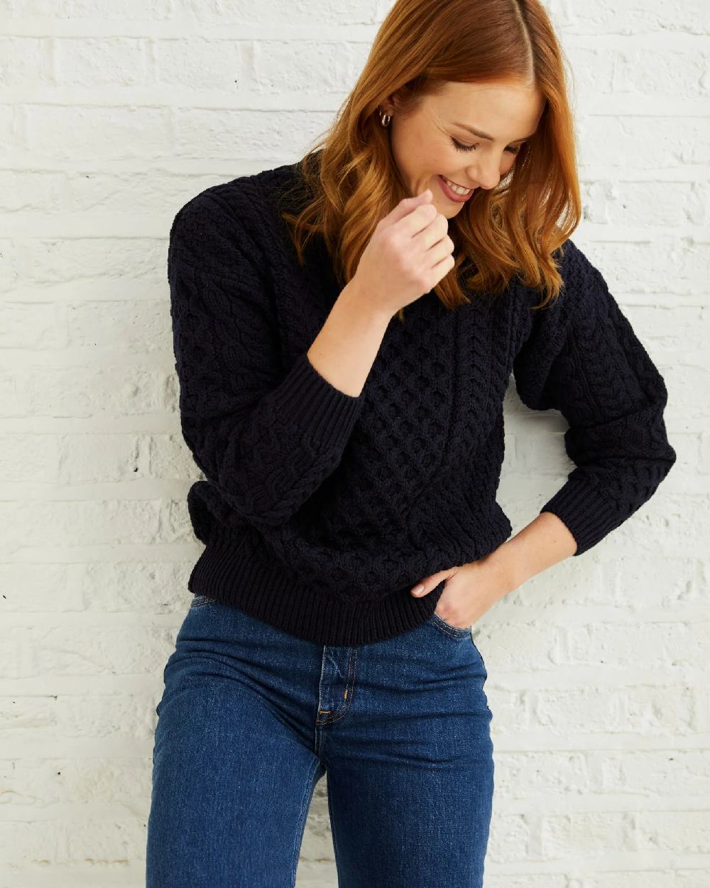 Navy Coloured Aran Inisheer Traditional Sweater on grey wall background 