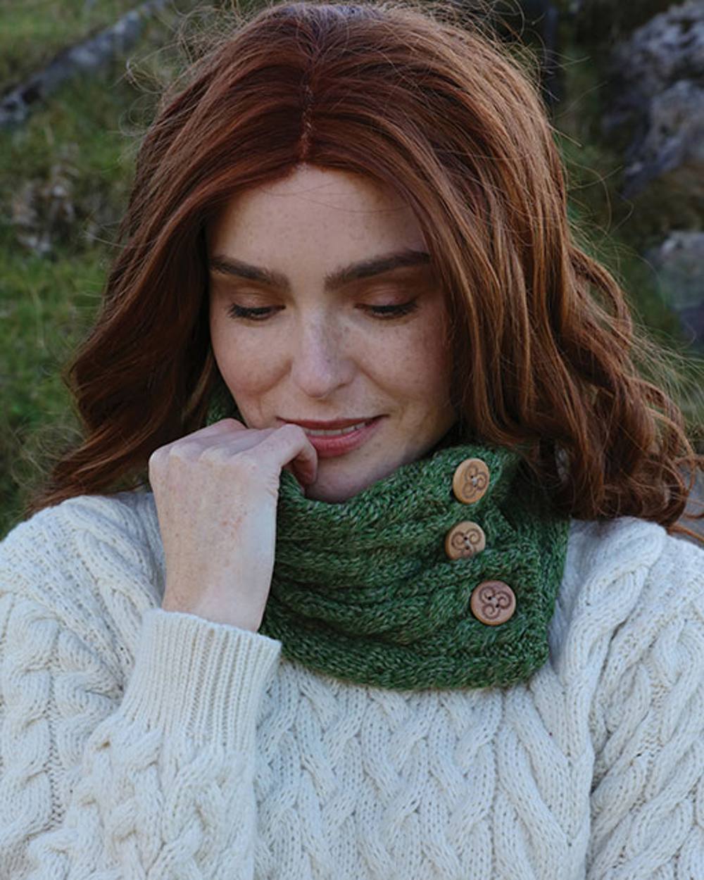 Sage Green colour Aran Merino Wool Button Snood on blurry background 