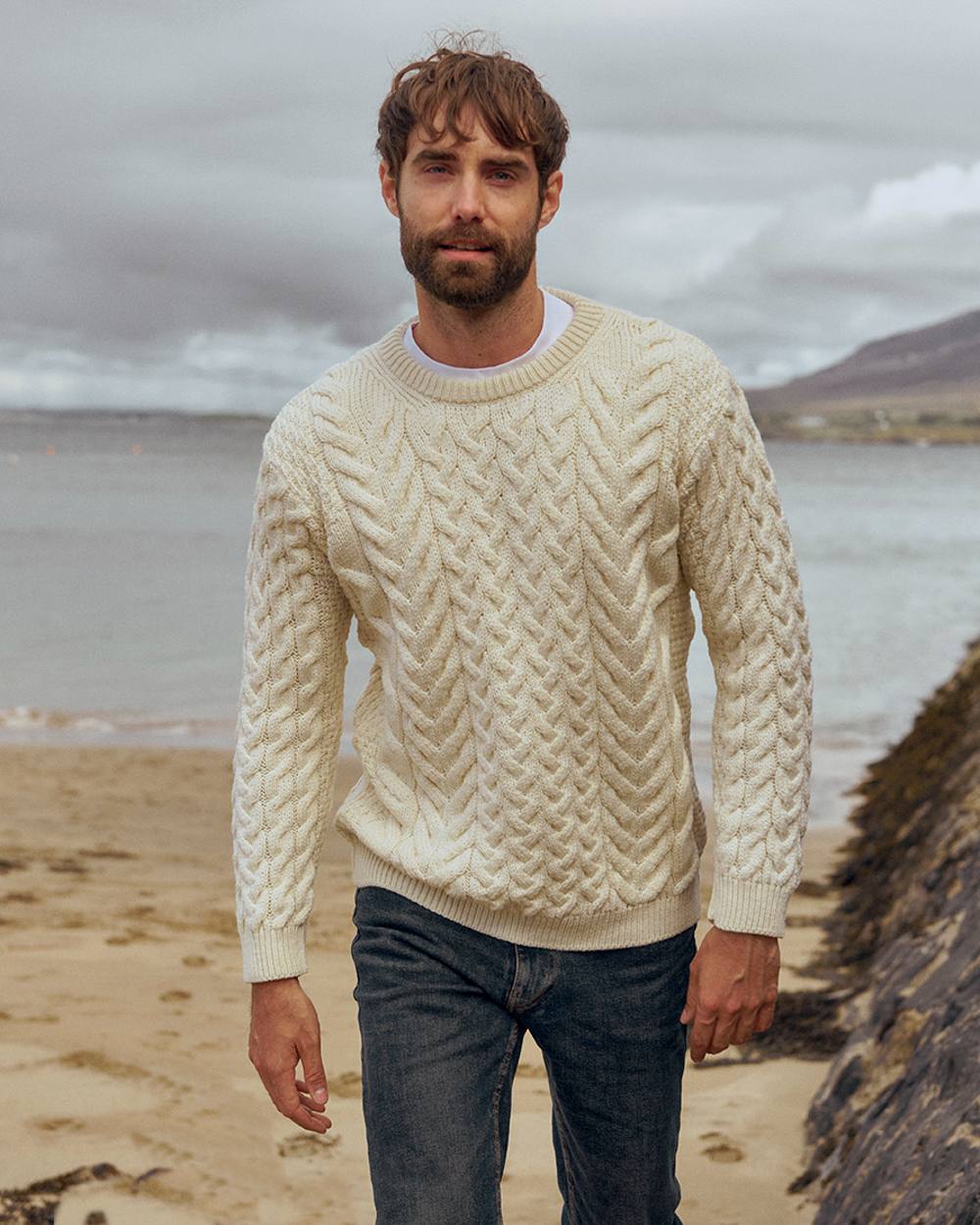 Cream Coloured Aran Merino Wool Crew Neck Jumper on sea background 