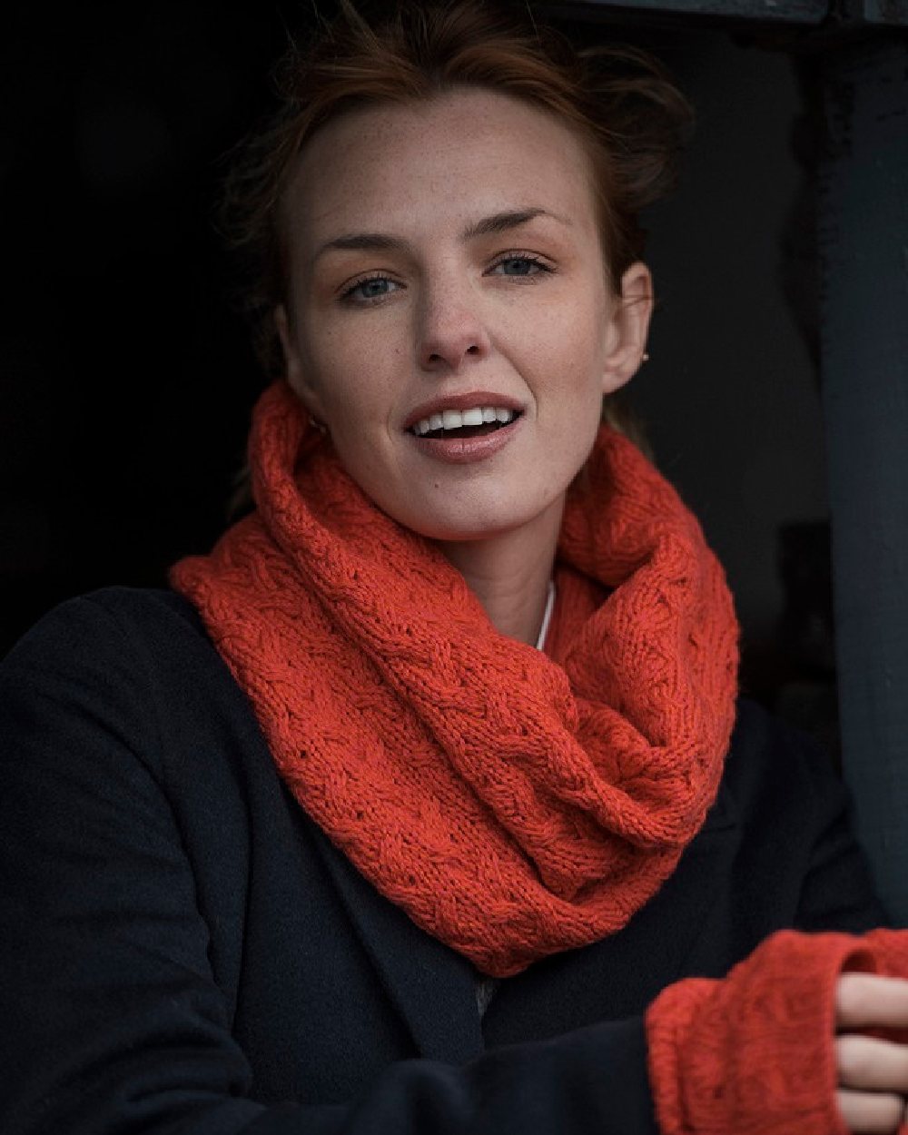 Coral coloured Aran Merino Wool Snood on black background 