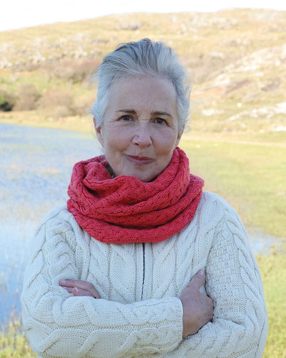 Coral coloured Aran Merino Wool Snood on blurry background 