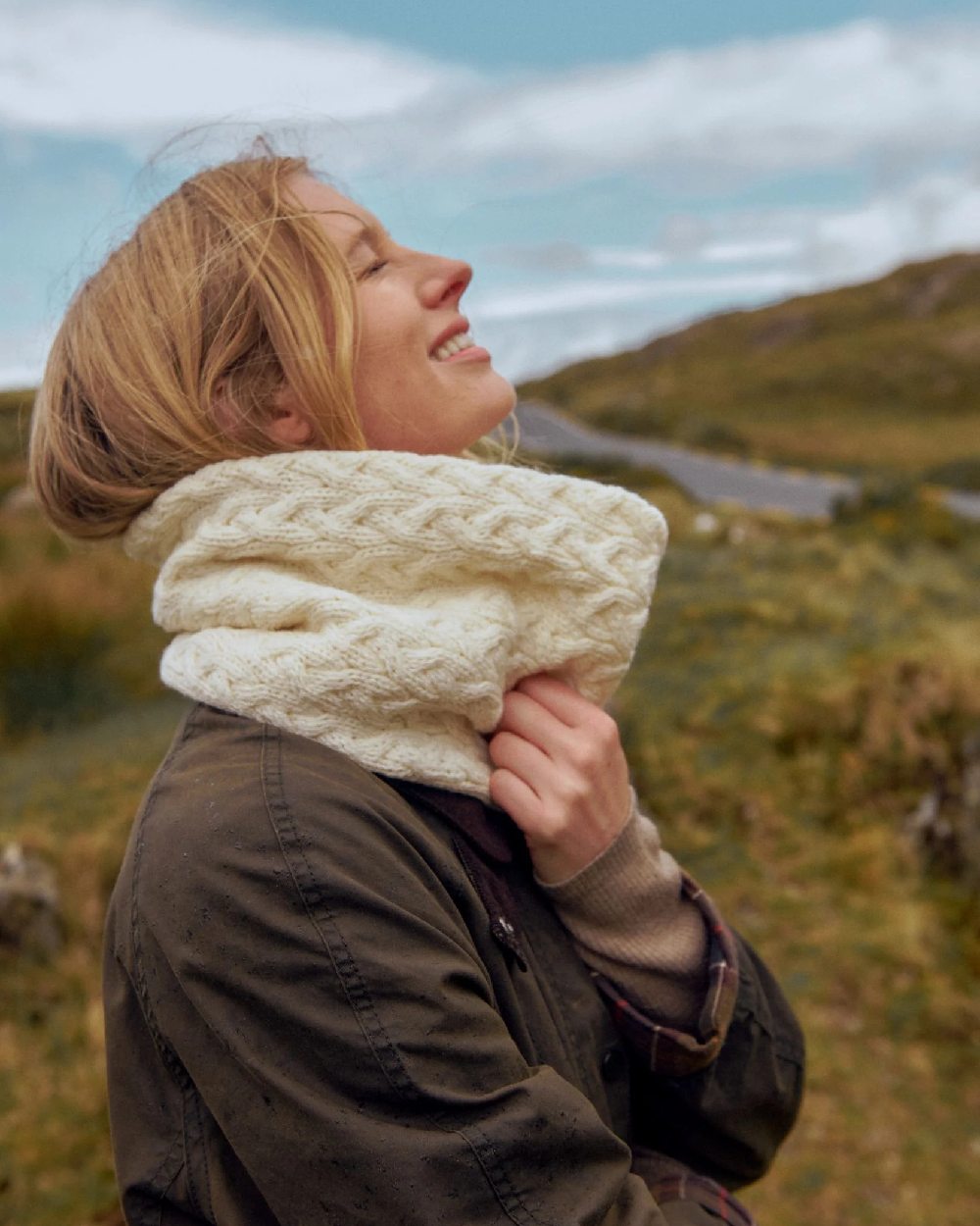 Cream coloured Aran Merino Wool Snood on blurry field background 