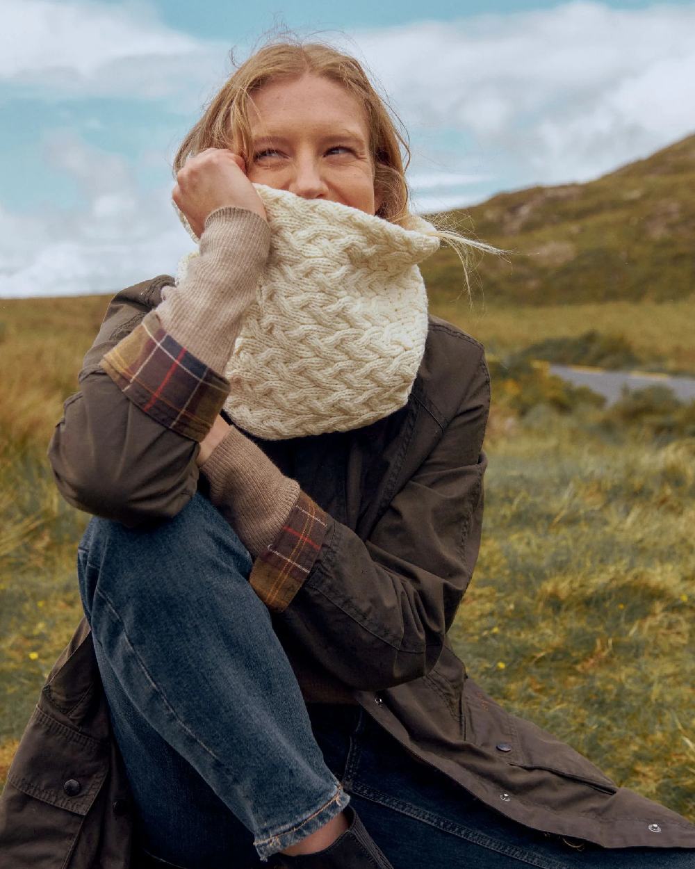 Cream coloured Aran Merino Wool Snood on blurry field background 