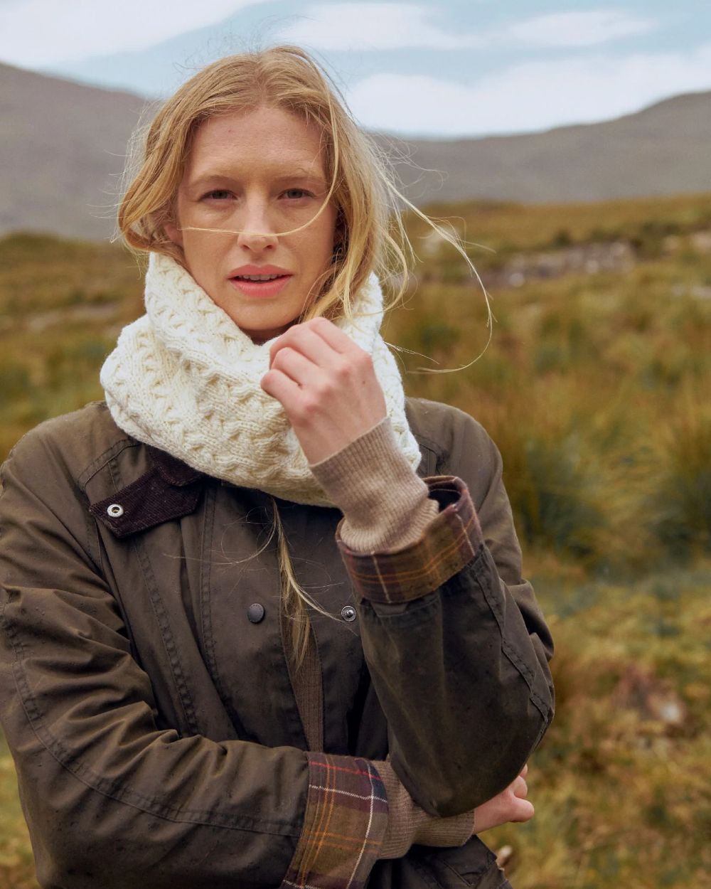 Cream coloured Aran Merino Wool Snood on blurry field background 