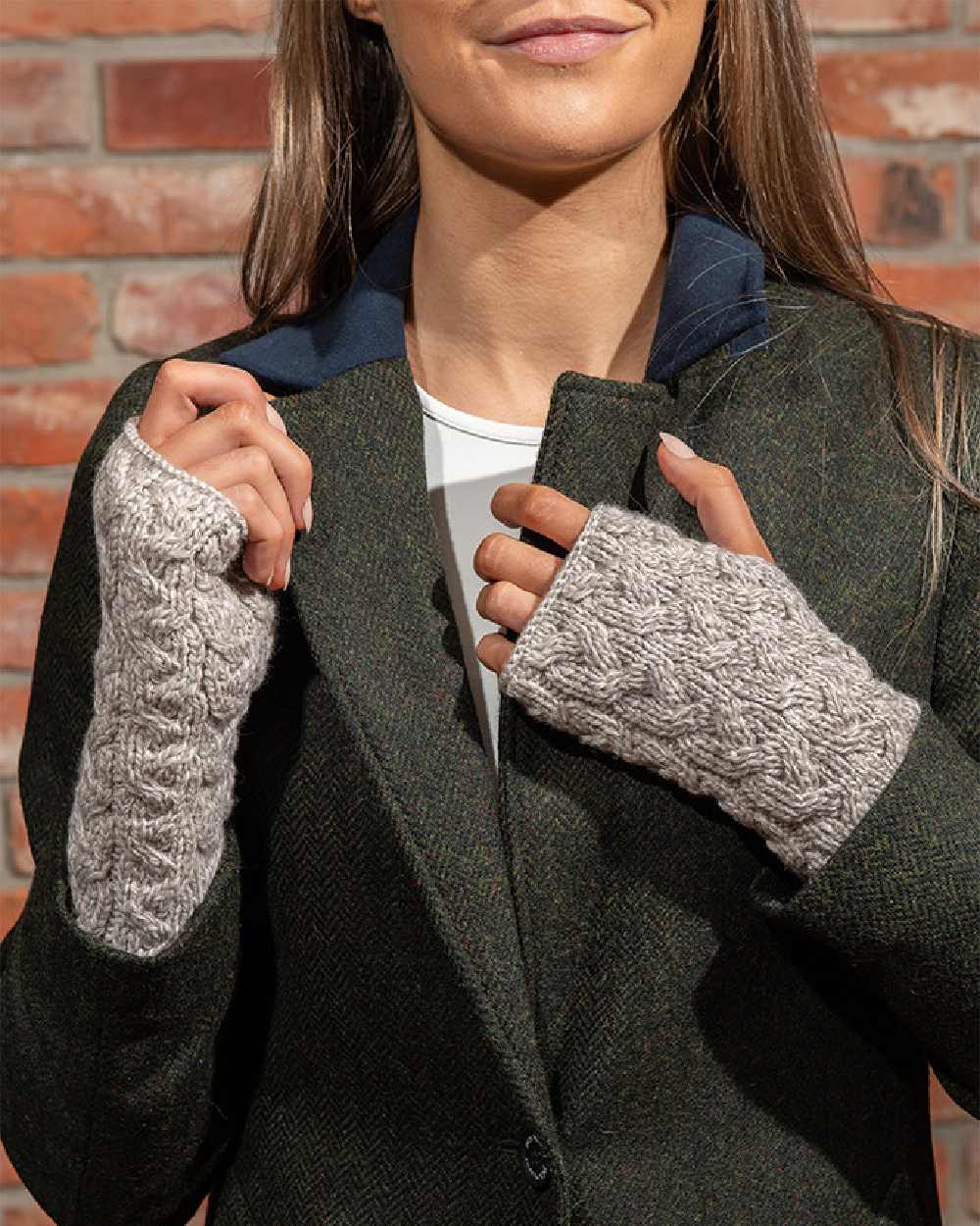 Oat Coloured Aran Supersoft Merino Fingerless Gloves on wall background 