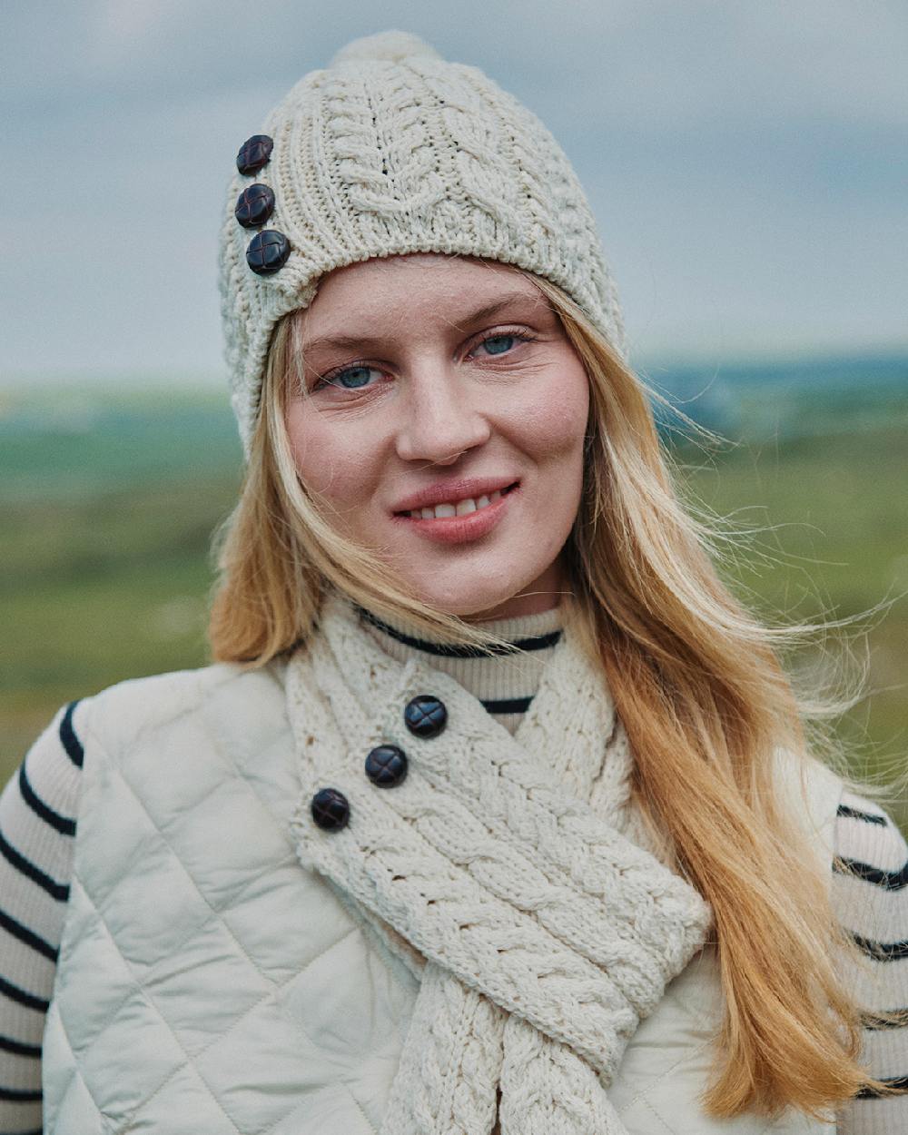Cream Coloured Aran Womens Cong Hat With Pom Pom on outdoor background 