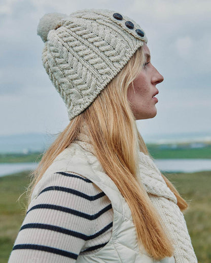 Cream Coloured Aran Womens Cong Hat With Pom Pom on outdoor background 