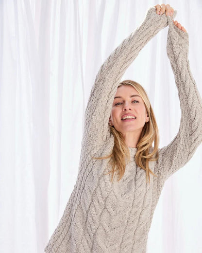 Oat Coloured Aran Womens Listowel Cabled Sweater on curtain background 