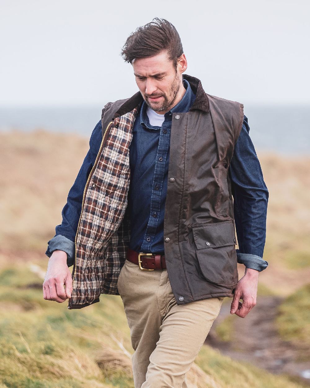 Dark wash coloured Hoggs of Fife Archerfield Denim Shirt on model with mountain background  