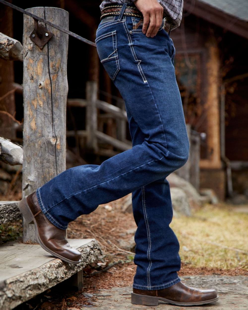 Oily Distressed Tan Coloured Ariat Mens Booker Ultra Square Toe Western Boot on wood house background 