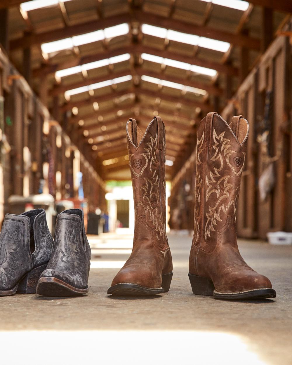 Distressed Brown Coloured Ariat Mens Heritage R Toe Western Boot on wooden house background 