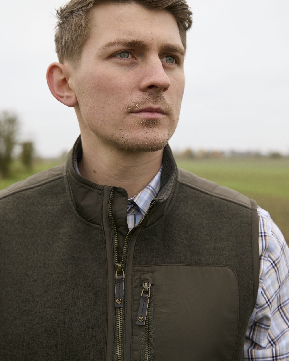 Earth coloured Ariat Mens Millbrae Gilet on field background 