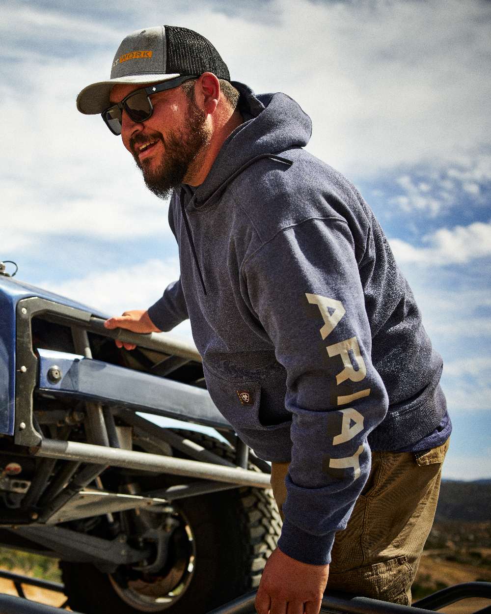 Navy Heather Alloy coloured Ariat Mens Rebar Lightweight Logo Hoodie on forest background 