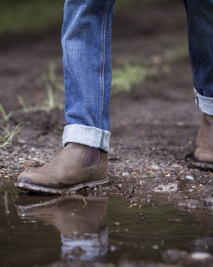 Java coloured Ariat Wexford Waterproof Boots on mud background 