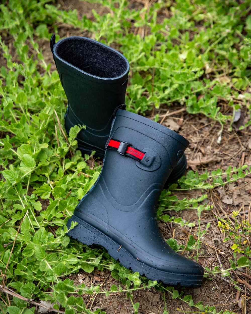 Navy coloured Ariat Womens Burford Wellington Boots on leafy background 