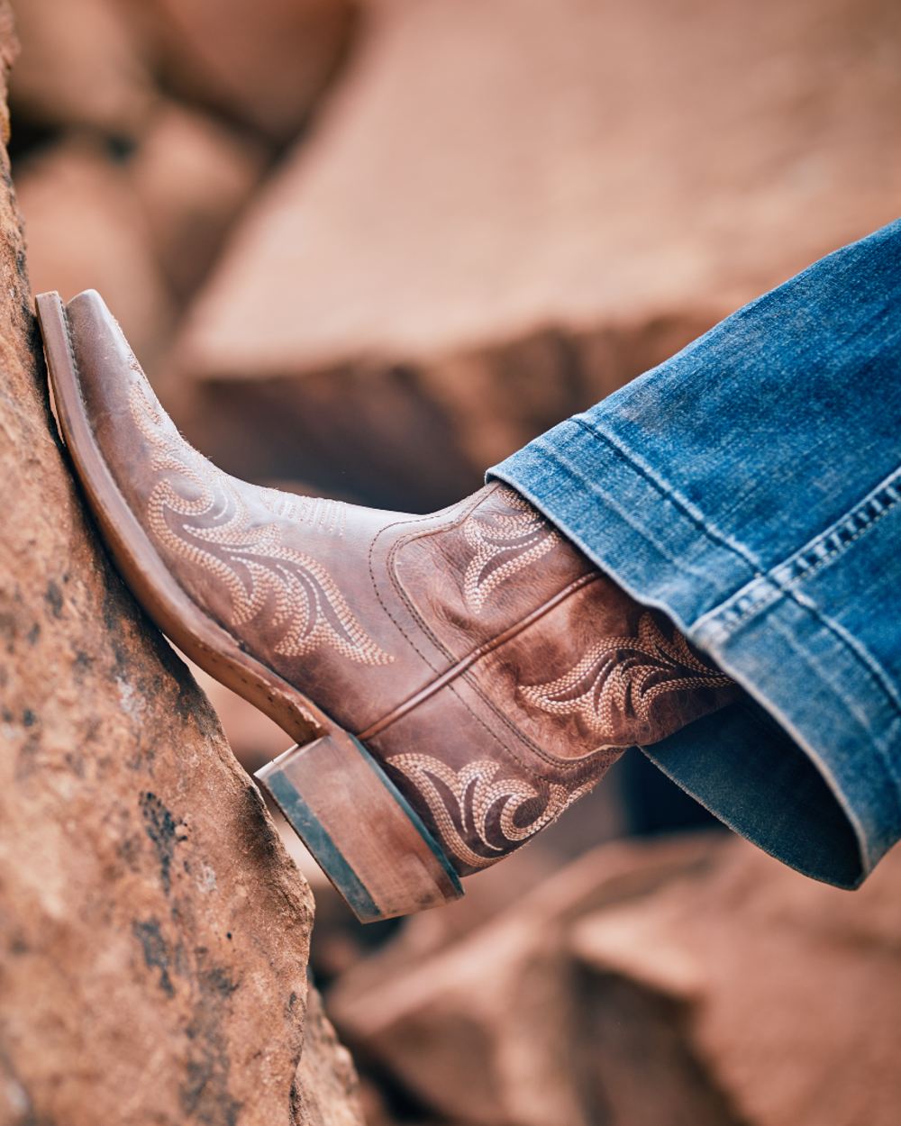 Whiskey Barrel coloured Ariat Womens Hazen Western Boot on rock background 