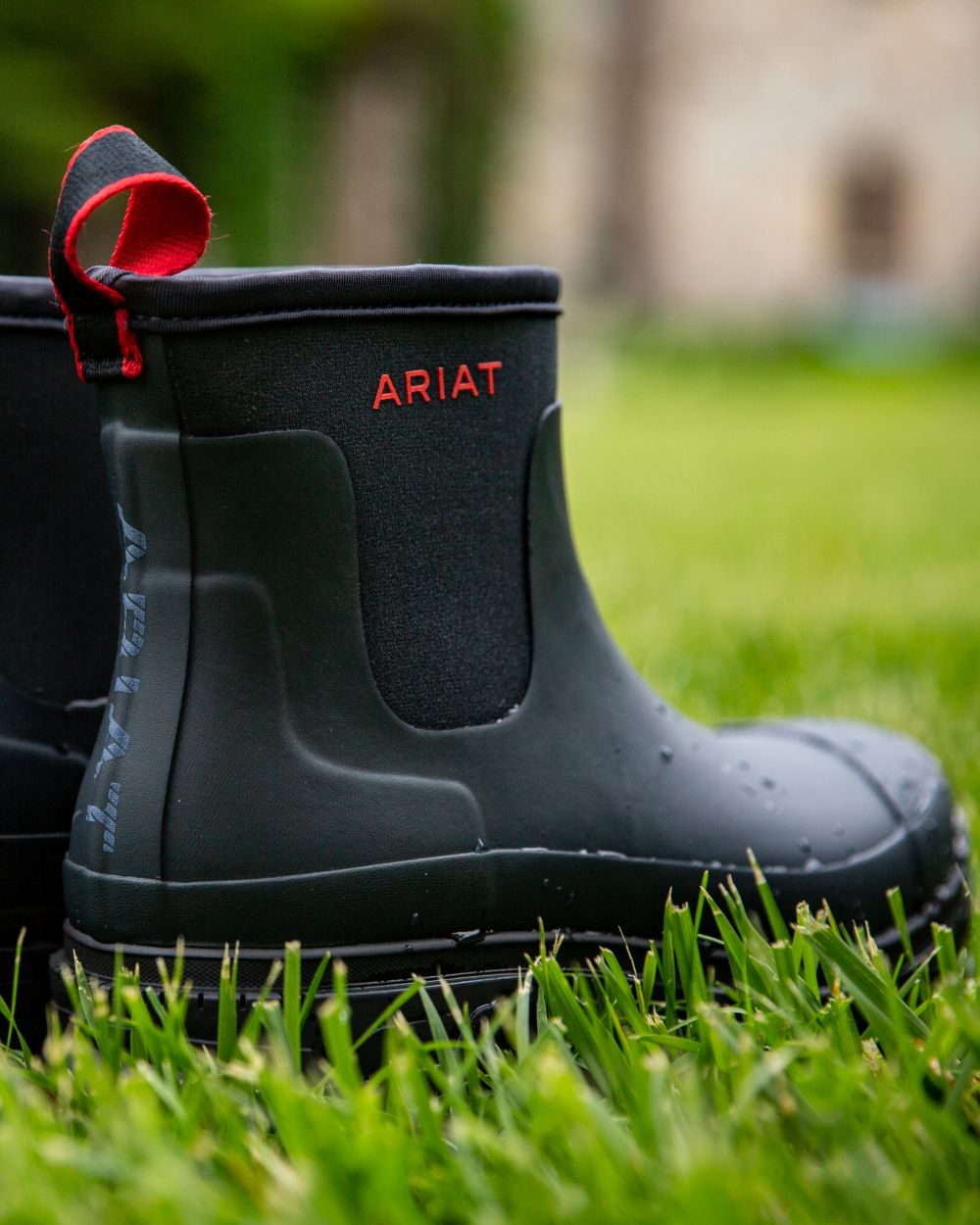 Navy coloured Ariat Womens Kelmarsh Shortie Rubber Boots on grass background 