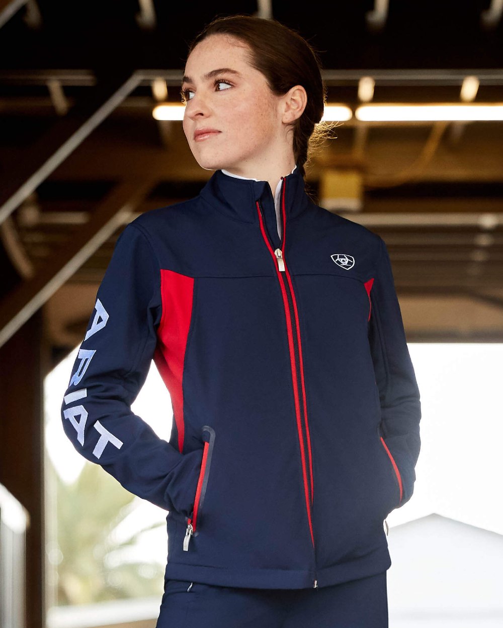 Navy Red coloured Ariat Womens New Team Softshell Jacket on outdoor background 