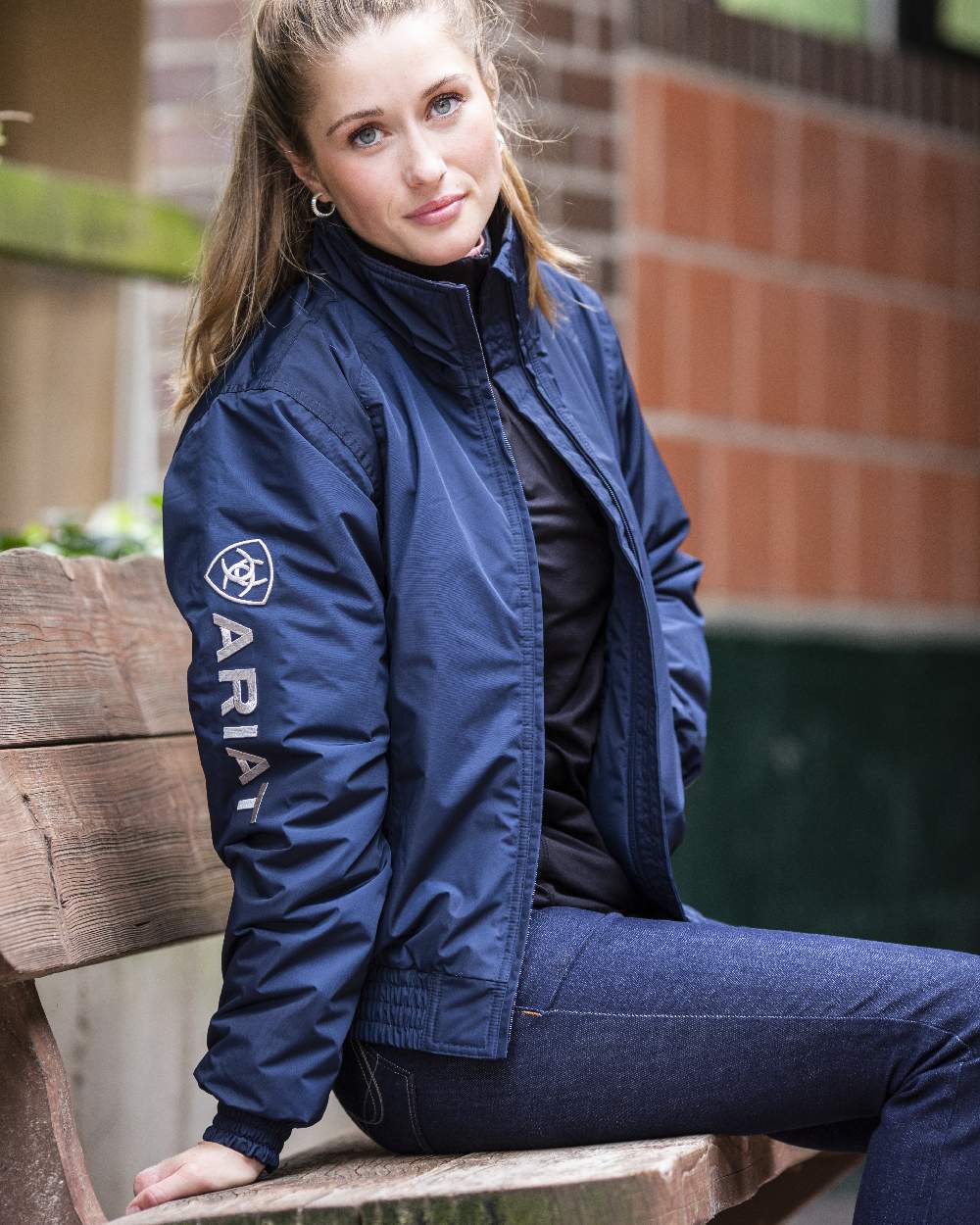 Navy Coloured Ariat Womens Stable Insulated Jacket on blurry wall background 