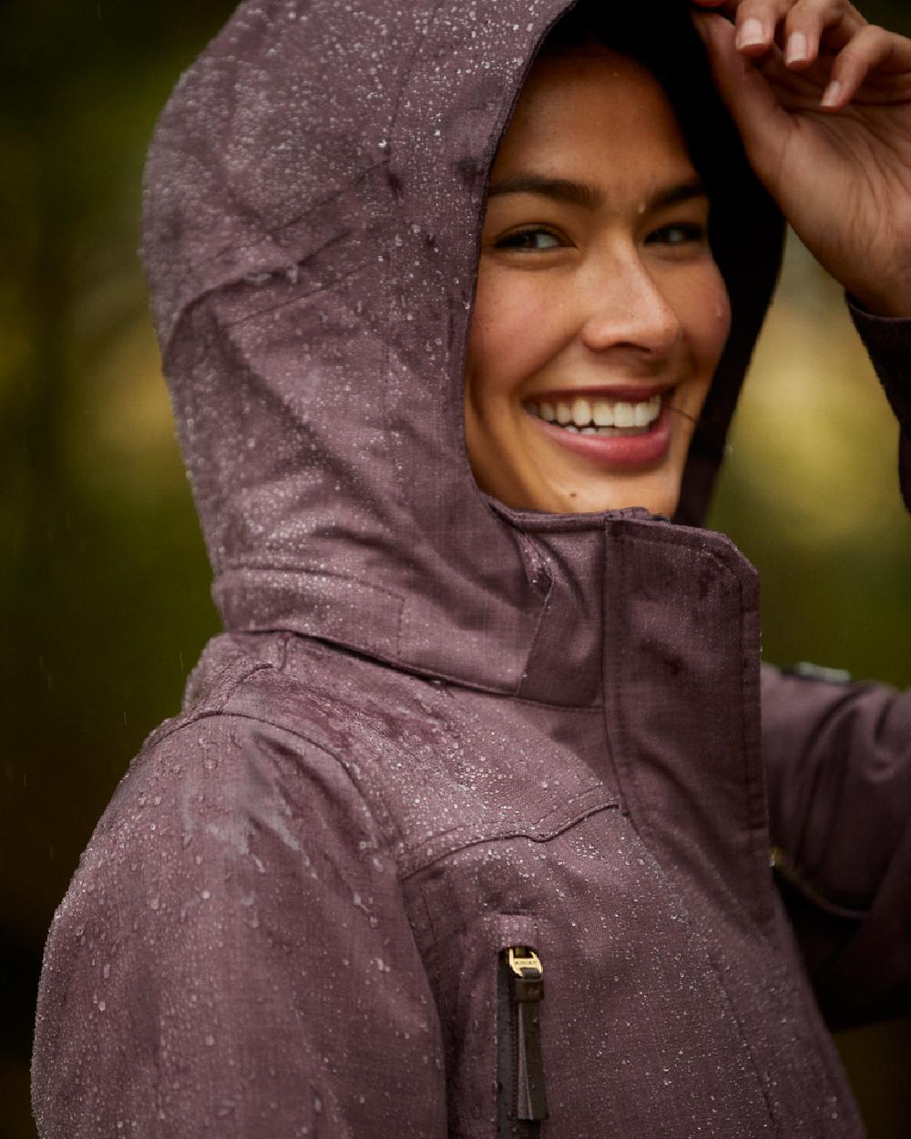 Raisin Coloured Ariat Womens Sterling Waterproof Insulated Parka on blurry background 