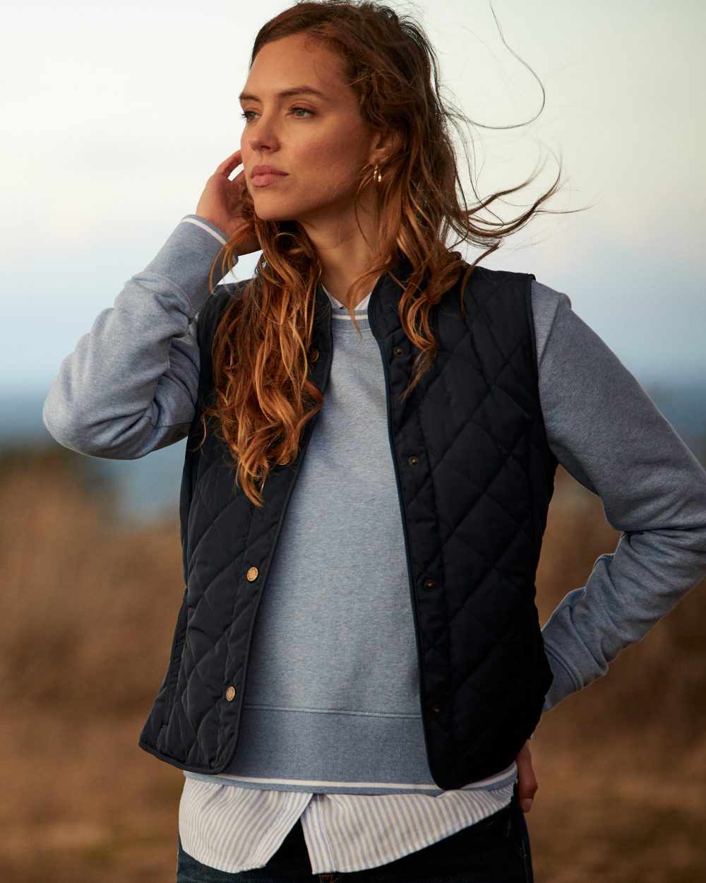 Navy Coloured Ariat Womens Woodside Quilted Gilet on field background 