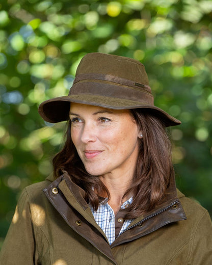 Pine Green Coloured Baleno Edith Waterproof Hat on blurry background 