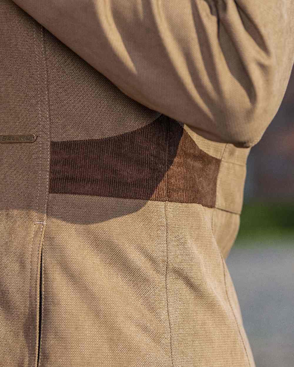 Camel Coloured Baleno Harmony Waterproof Coat on blurry background 