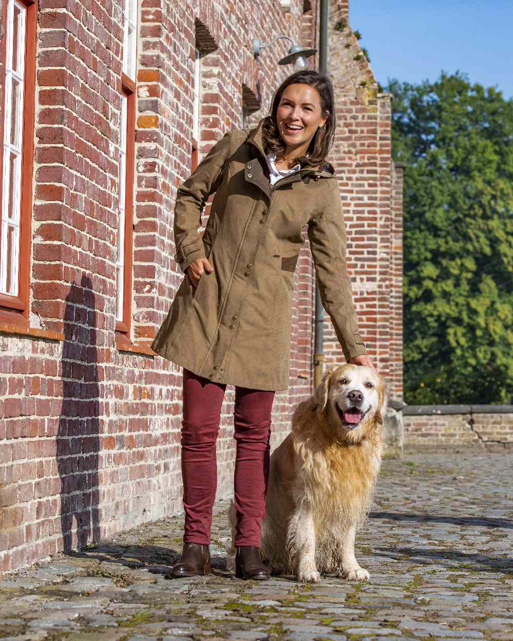 Camel Coloured Baleno Harmony Waterproof Coat on building background 