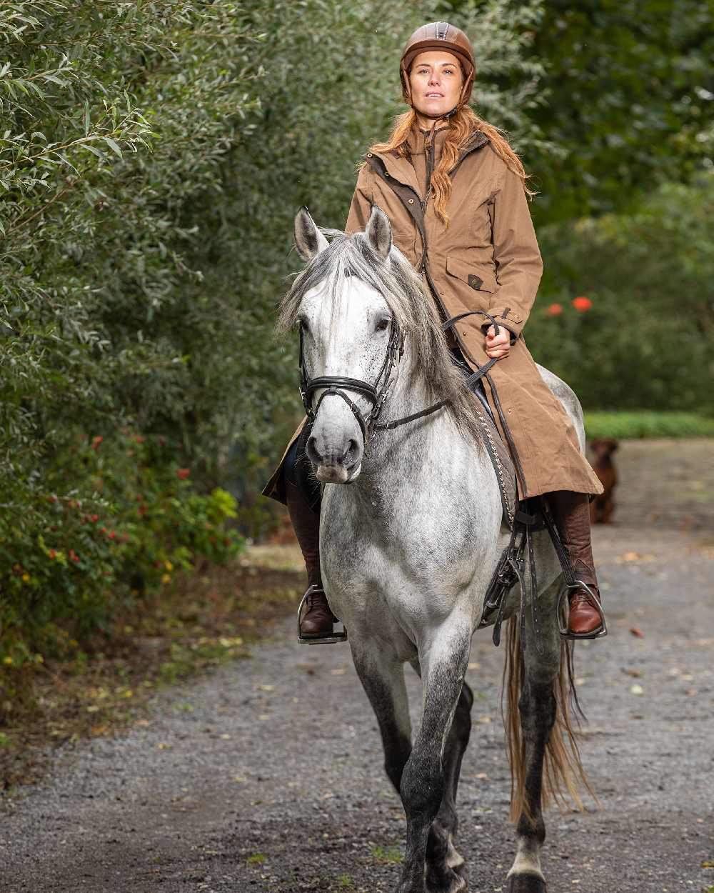 Camel Coloured Baleno Kensington Long Waterproof Coat on countryside background 