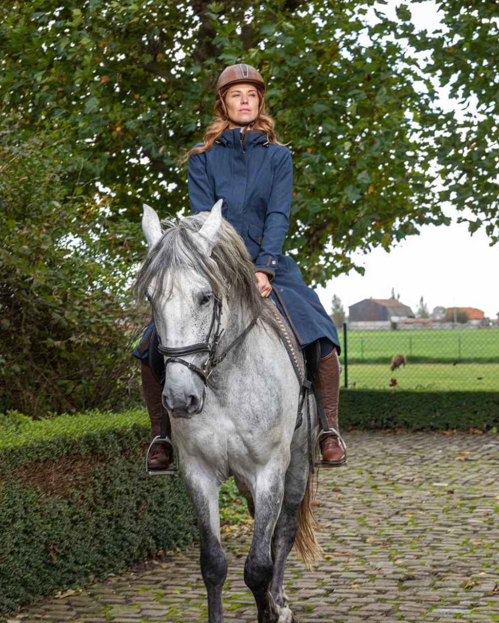 Navy Blue Coloured Baleno Kensington Long Waterproof Coat on countryside background 