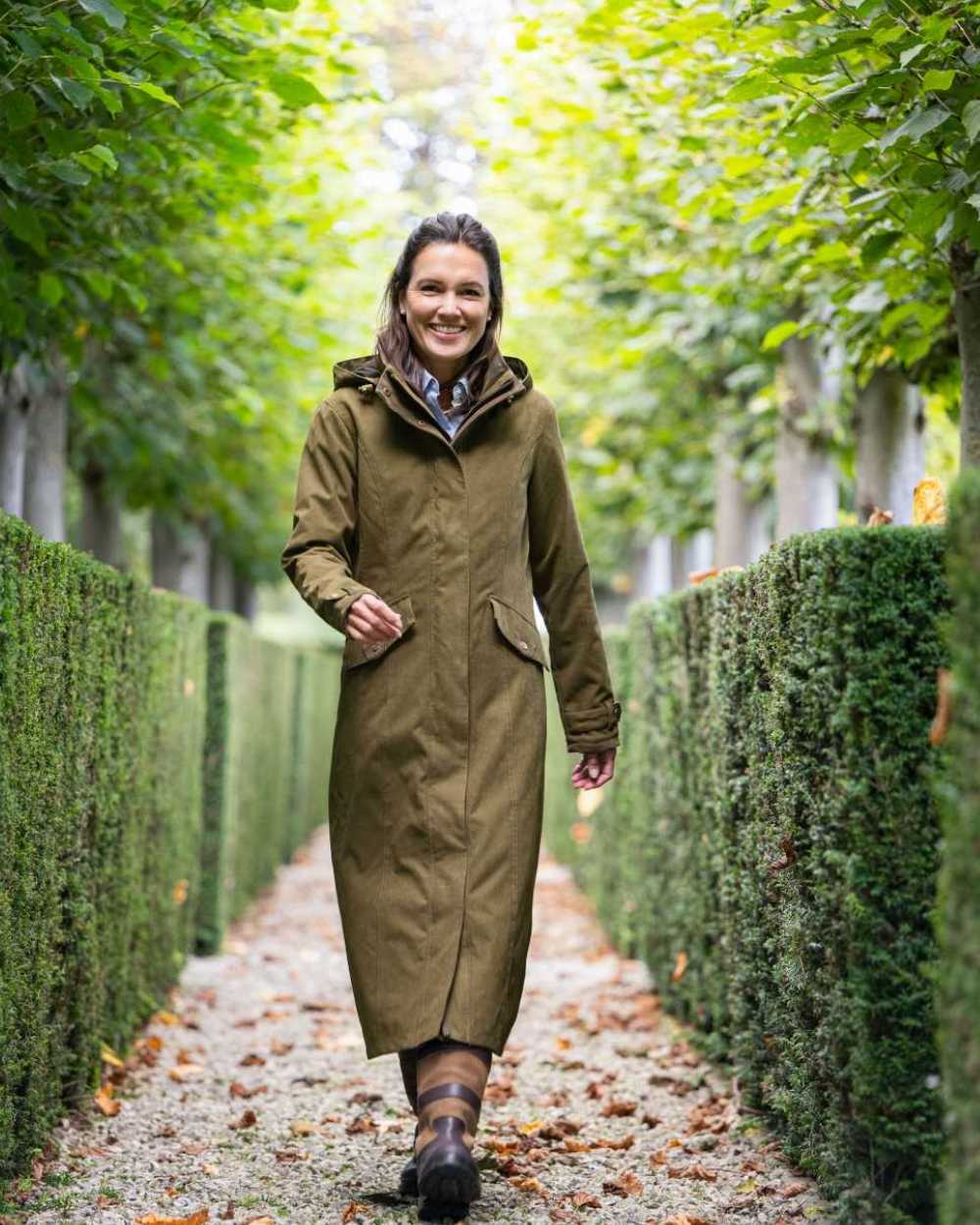 Pine Green Coloured Baleno Kensington Long Waterproof Coat on countryside background 