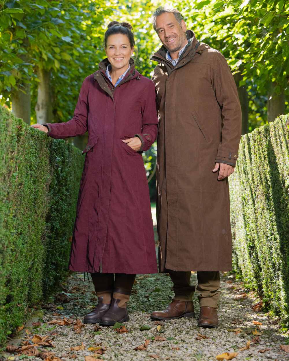 Raspberry Coloured Baleno Kensington Long Waterproof Coat on countryside background 