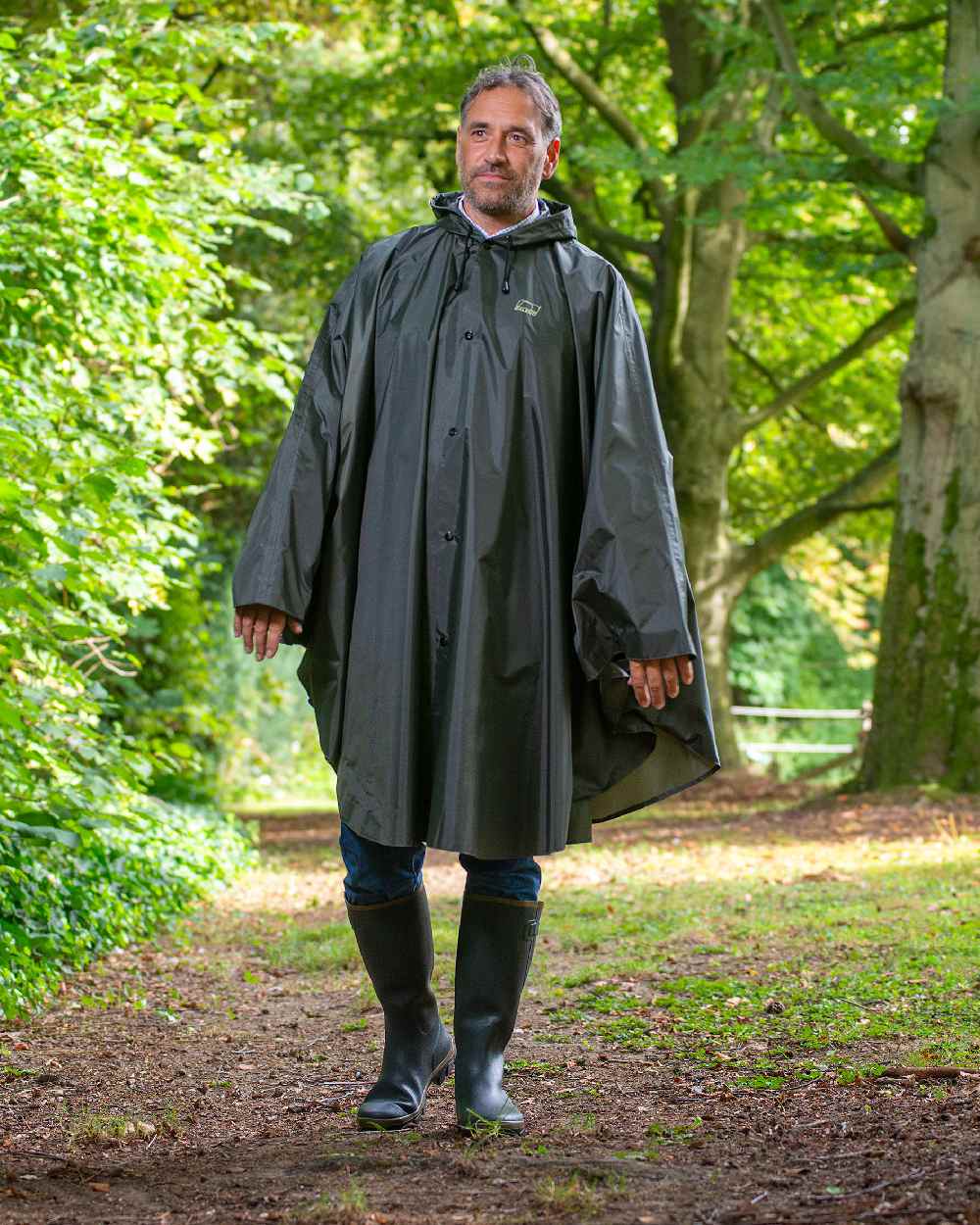 Khaki Coloured Baleno Tornado Nylide Rain Poncho on countryside background 