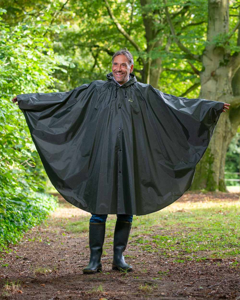 Khaki Coloured Baleno Tornado Nylide Rain Poncho on countryside background 