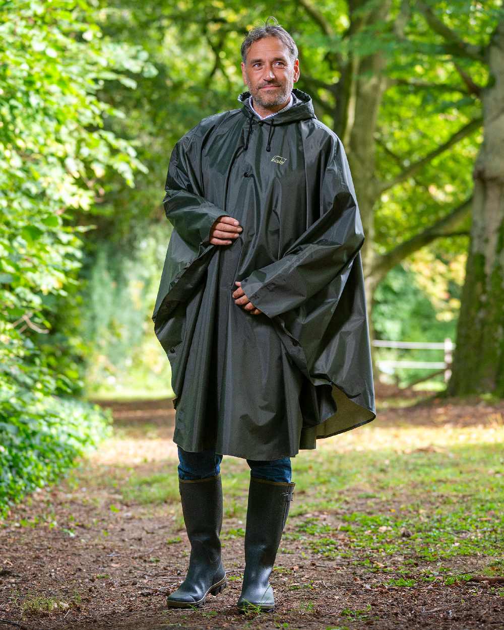 Khaki Coloured Baleno Tornado Nylide Rain Poncho on countryside background 