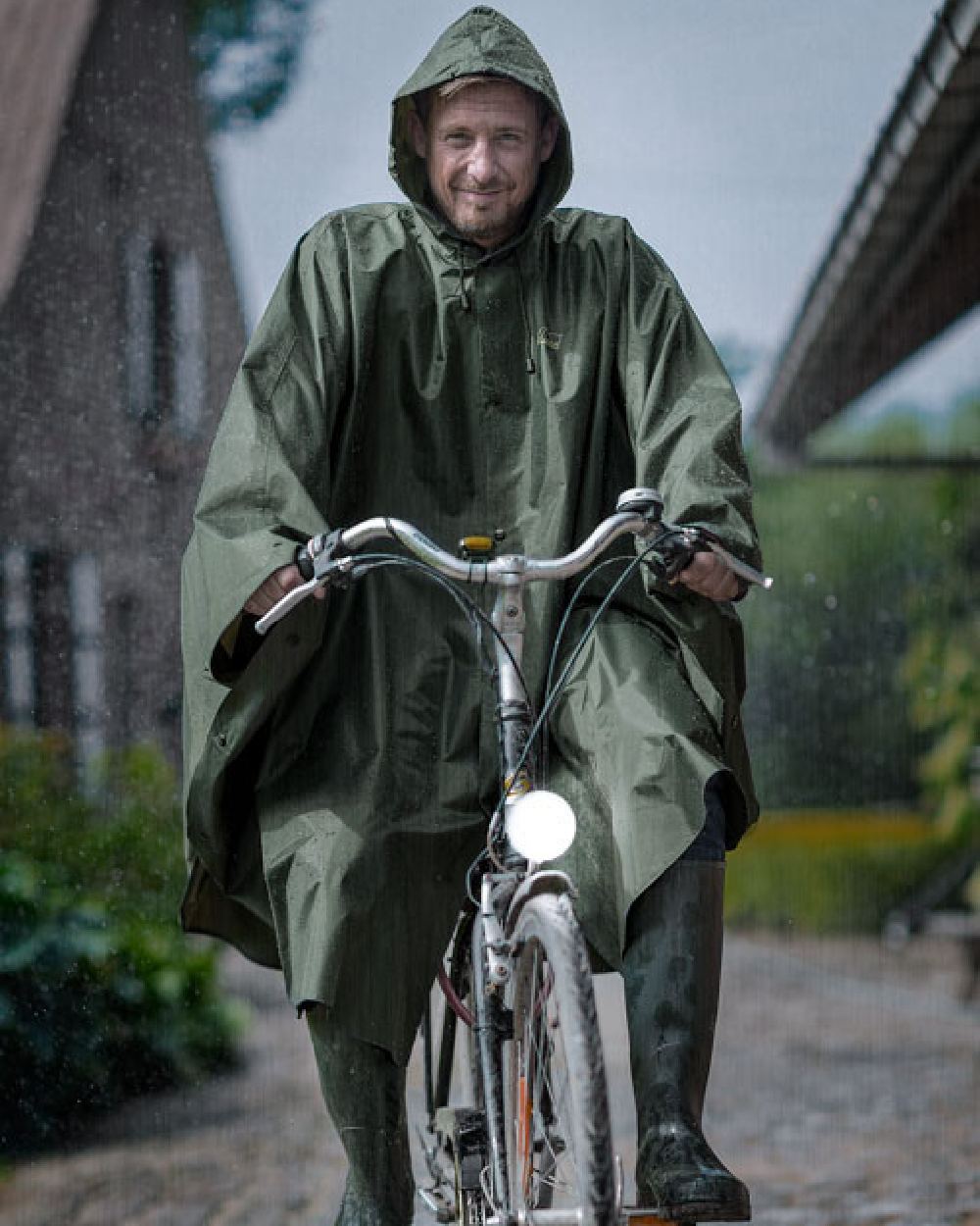 Khaki Coloured Baleno Tornado Nylide Rain Poncho on countryside background 