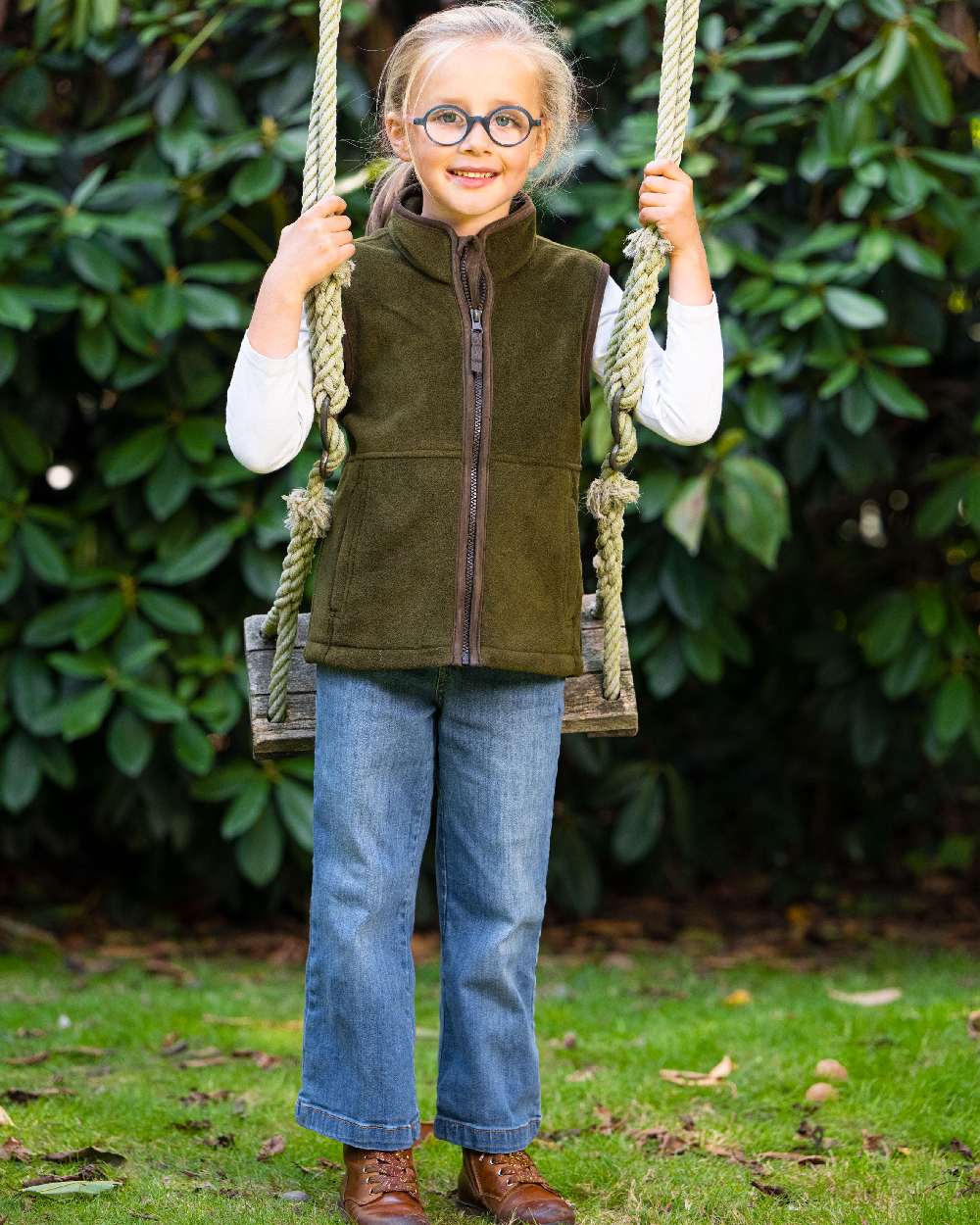 Olive Coloured Baleno Wizz Kids Fleece Gilet on park background 