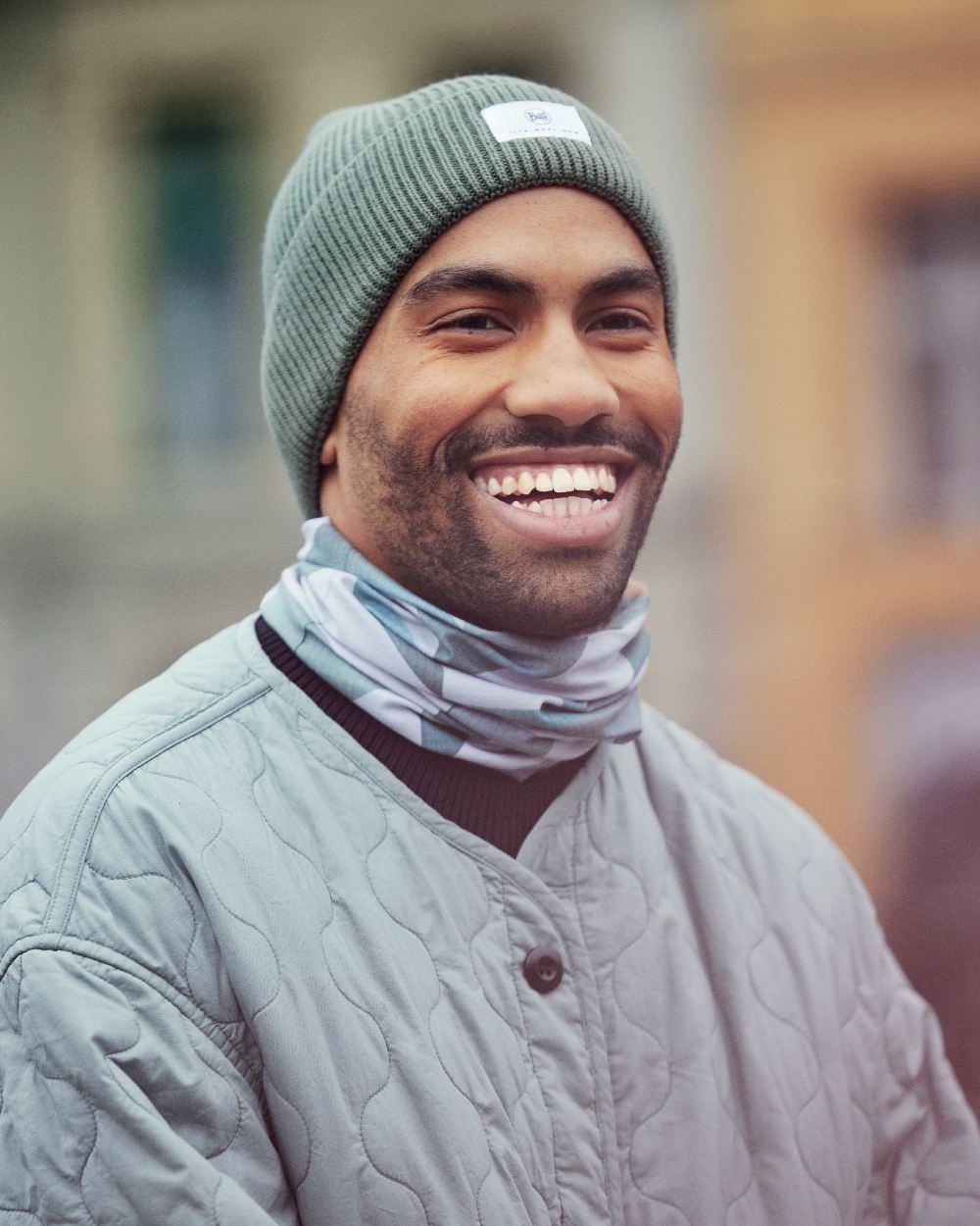 Silversage Coloured Buff Drisk Knitted Beanie on blurry background 