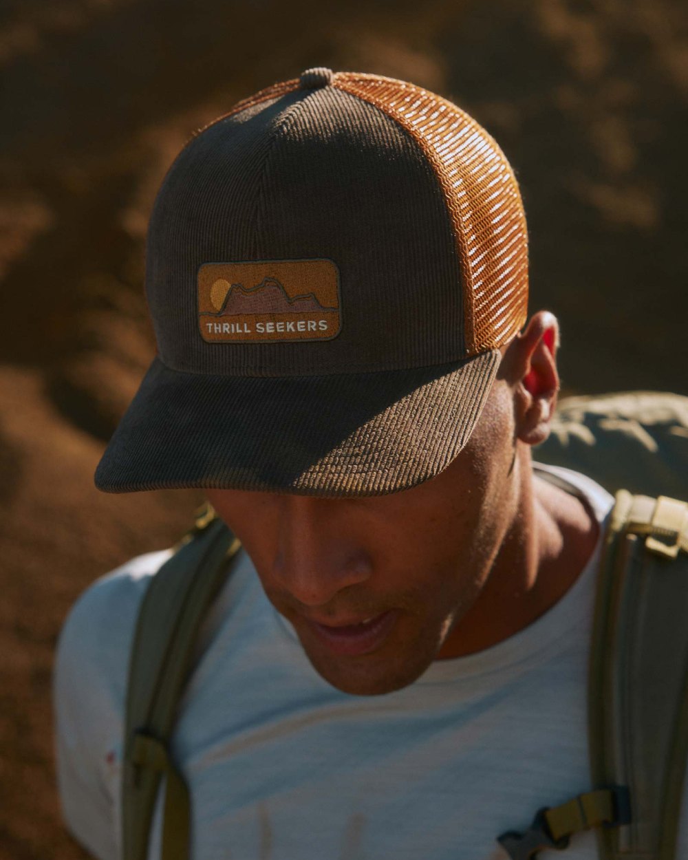 Brown Coloured Buff Explore Trucker Cap on ground background 