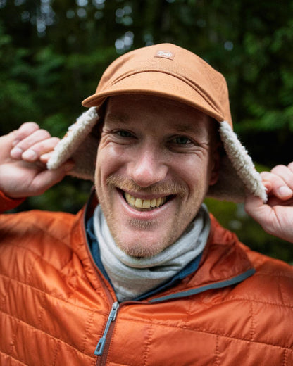 Copper Coloured Buff Simu Fall Line Cap on blurry background 