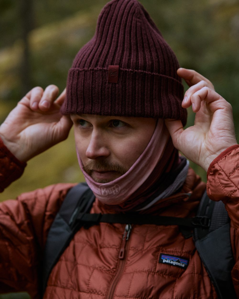 Maroon Coloured Buff Knitted Norval Beanie on blurry background 