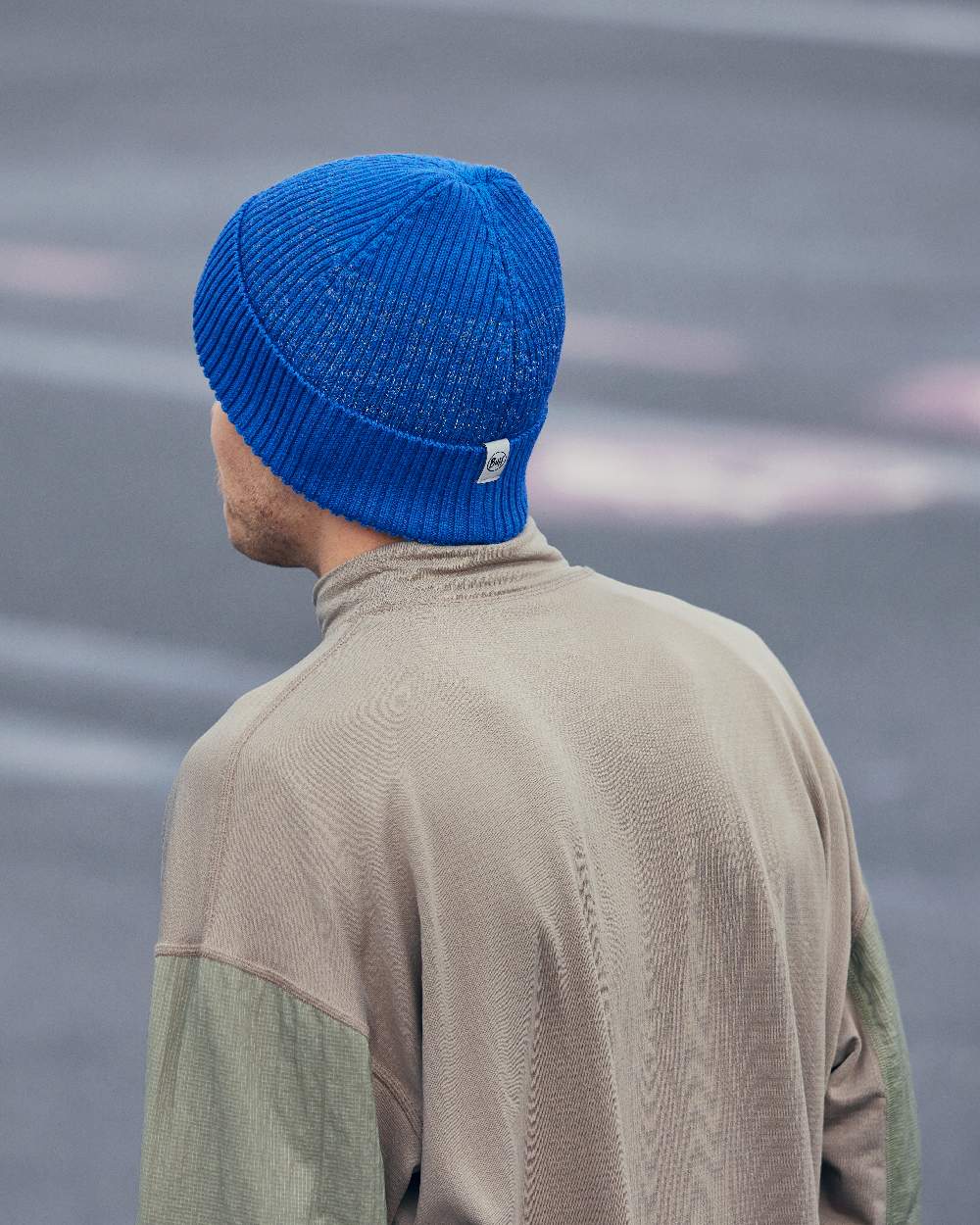 Cobalt Coloured Buff Merino Active Beanie on blurry background 